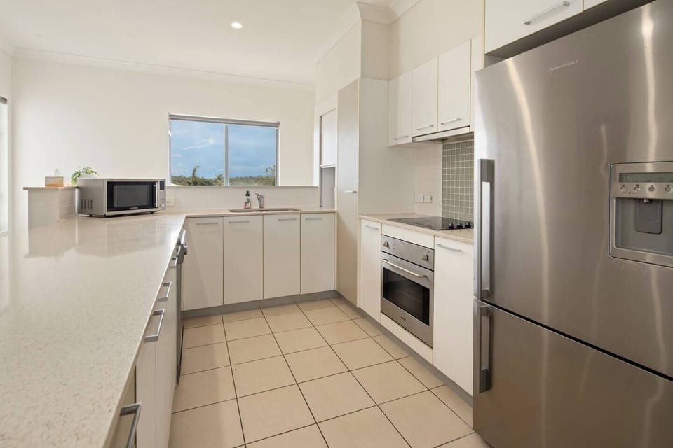 Whip up delicious meals in the light-filled kitchen featuring a full-size fridge with ice and water dispenser, oven, stovetop, microwave, dishwasher, and essential cookware.