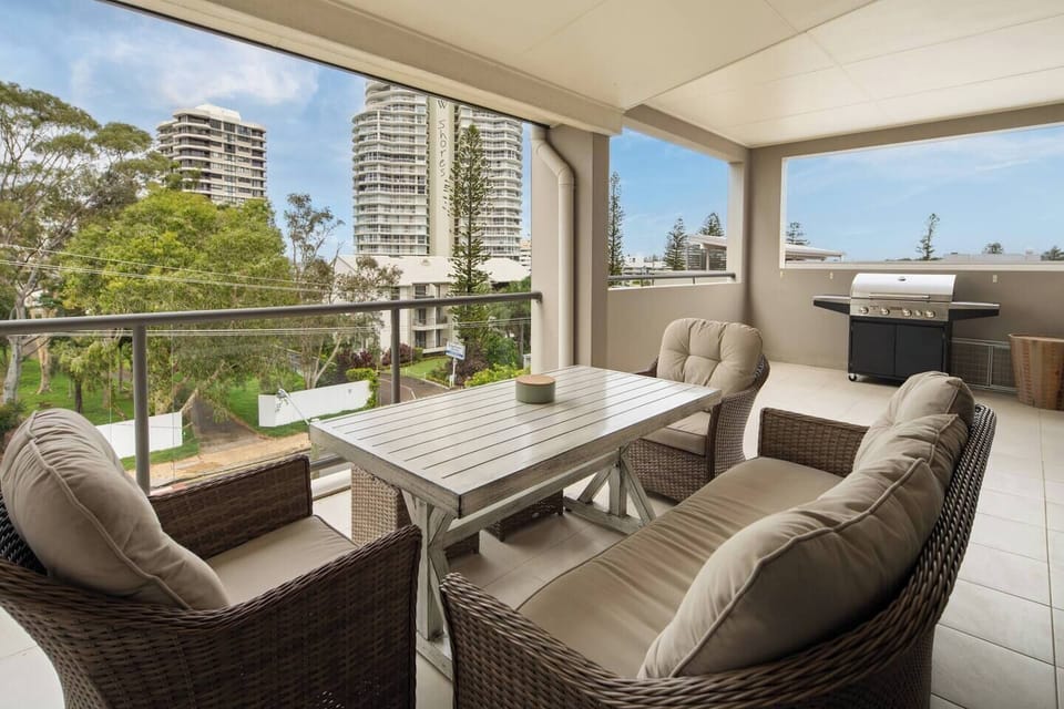 Savour sea breezes from the covered balcony, complete with cushioned seating, a dining table, and a gas BBQ, perfect for relaxed meals overlooking the Broadwater skyline.