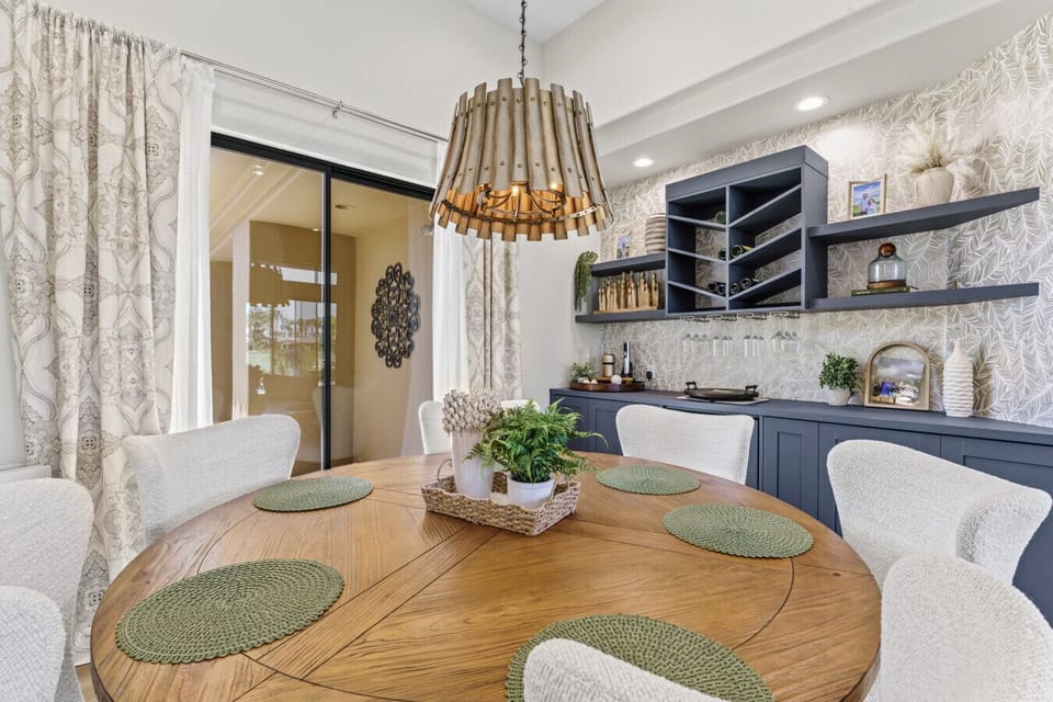 Dining area w/ textured accent wall, statement lighting & built-in shelving