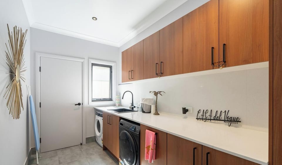 A tidy and well-organized laundry or utility space with warm wood finishes.