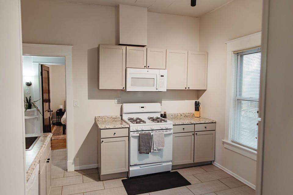 Bright, fully equipped kitchen with granite countertops, gas range, and ample cabinet space—perfect for comfortable monthly stays.