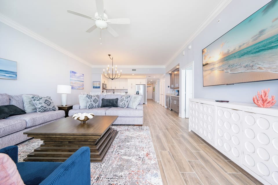 Relax in the inviting living area with cozy seating, a large TV, and a stylish coffee table, perfect for gatherings