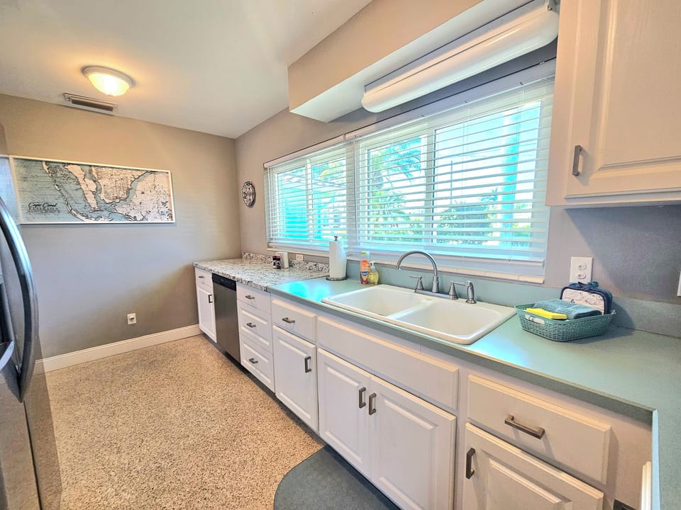 Kitchen with large windows, new blinds, counter space, and new dishwasher 