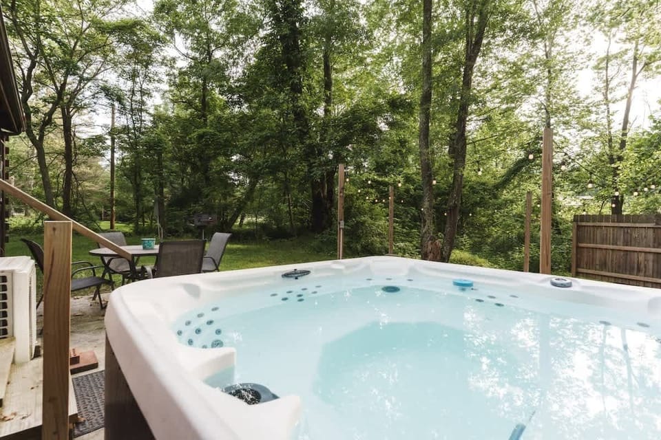 Relax in the outdoor hot tub surrounded by peaceful trees & a private fenced yard