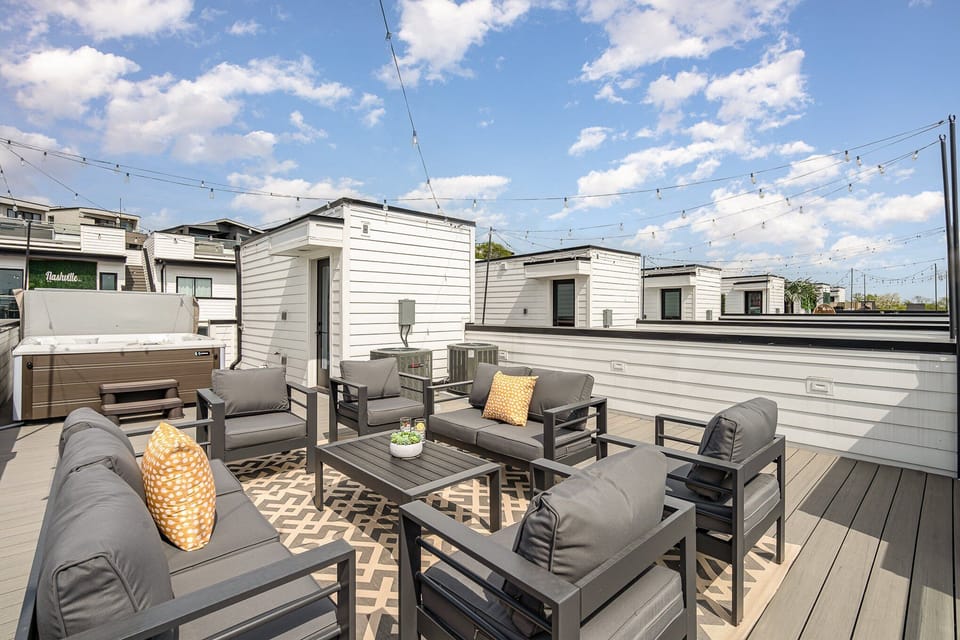 3rd Unit (4th Floor): Private rooftop deck with hot tub, outdoor seating, bistro lighting, and stunning city skyline views.
