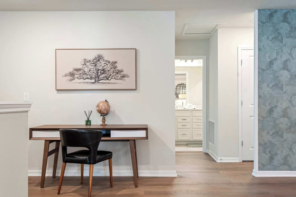 Cozy workspace nook with modern desk, stylish chair, and peaceful wall art.
