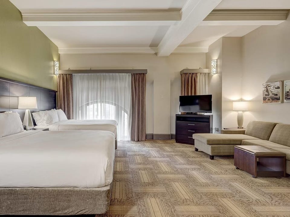 Unwind in a spacious suite with beds and cozy lounge.