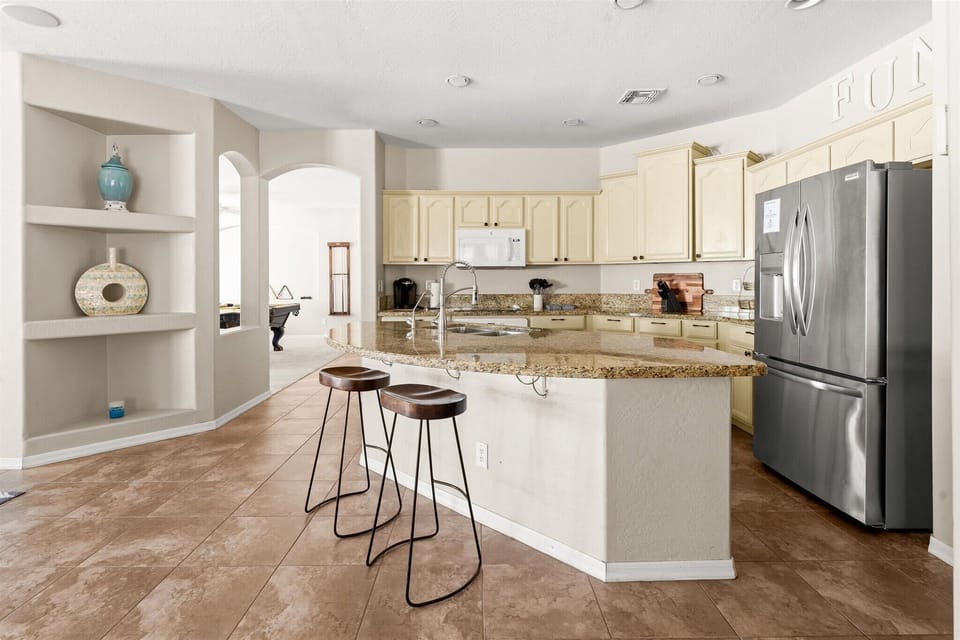 Whip up meals with ease in this fully stocked kitchen—complete with a spacious island and high-top seating for casual bites!