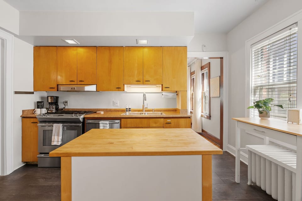 Your spacious kitchen invites culinary adventures with warm wood cabinetry, modern appliances, and a central island perfect for morning coffee or meal prep.