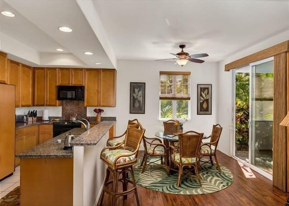 Charming breakfast nook with rattan seating, beautiful garden views, and casual island vibes.