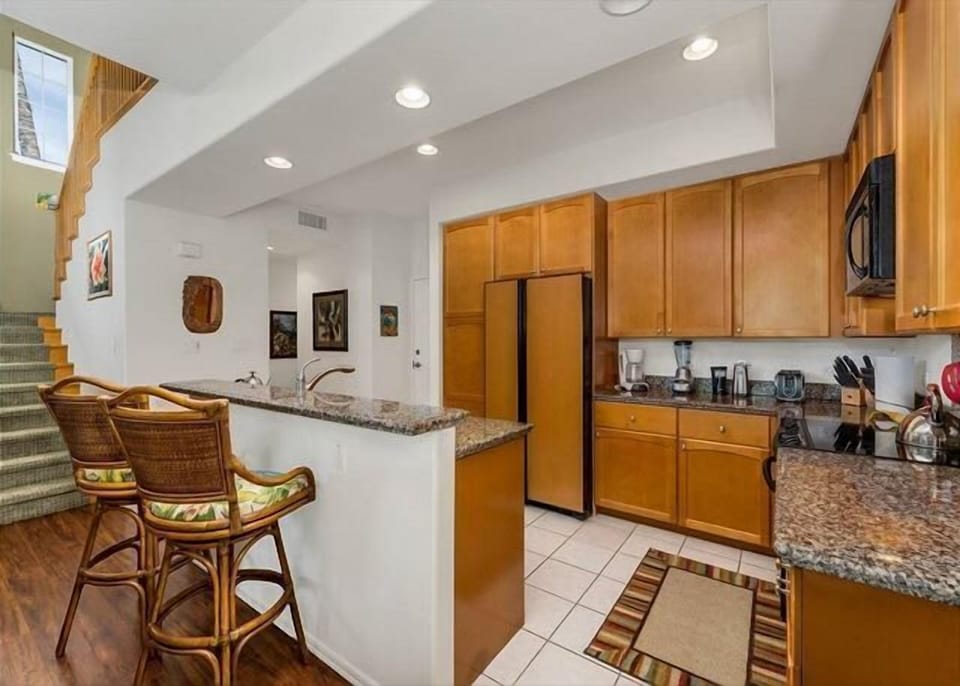 Modern kitchen with granite counters, full size appliances, and breakfast bar seating with flair.

