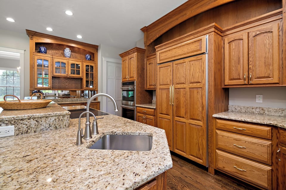 Custom wood work cabinetry, granite counters, Thermador Sub Zero fridge, double GE Cafe ovens, and island sink with dedicated faucet to provide reverse osmosis filtered drinking water