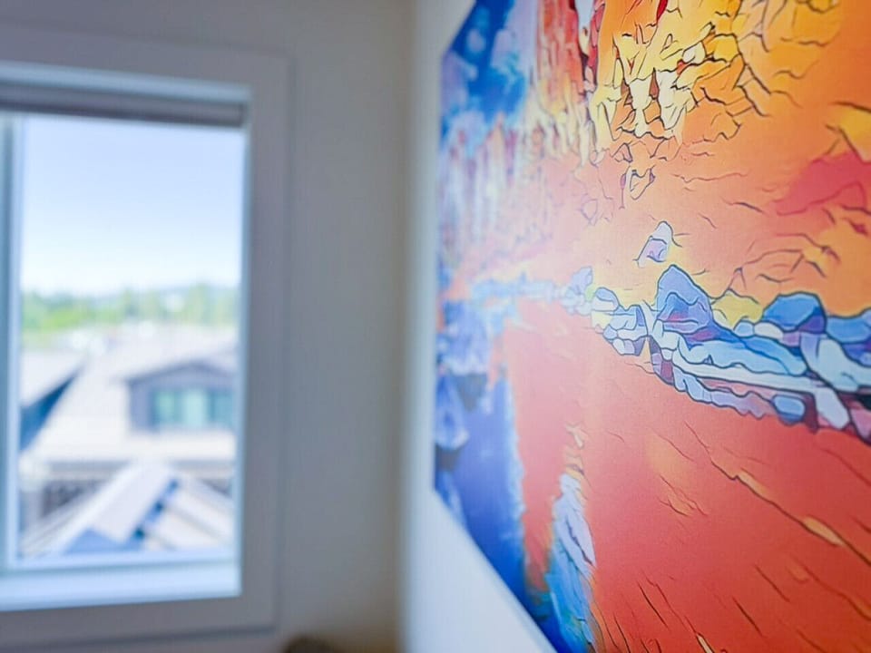 Wake up to a vibrant blend of local art and rooftop mountain views—captured here from the master bedroom window.