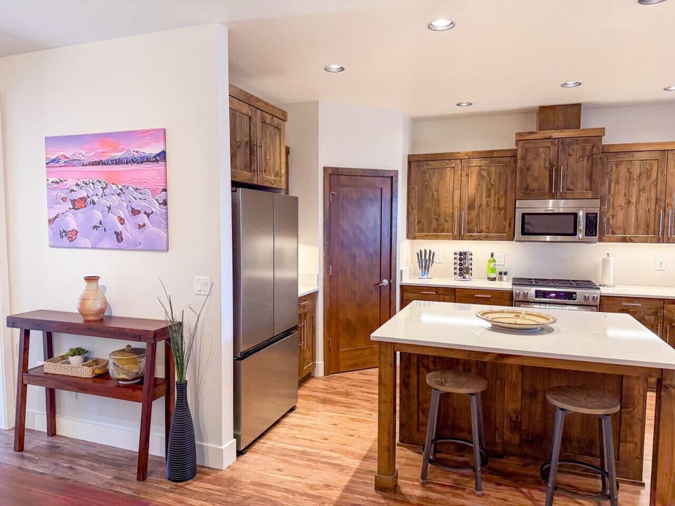 Fully equipped kitchen featuring rich wood cabinetry, quartz countertops, and modern stainless steel appliances—perfect for everything from morning coffee to evening gatherings.
