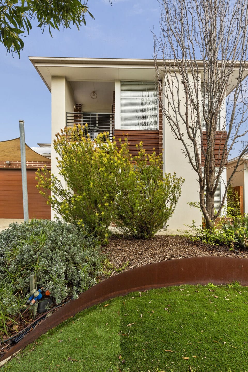 Landscaped exterior with garden greenery and private entry