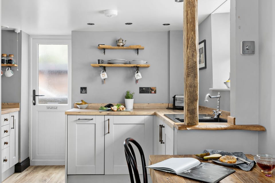 Kitchen area with slim dishwasher, pod coffee machine and access to outside - Apothecary Cottage