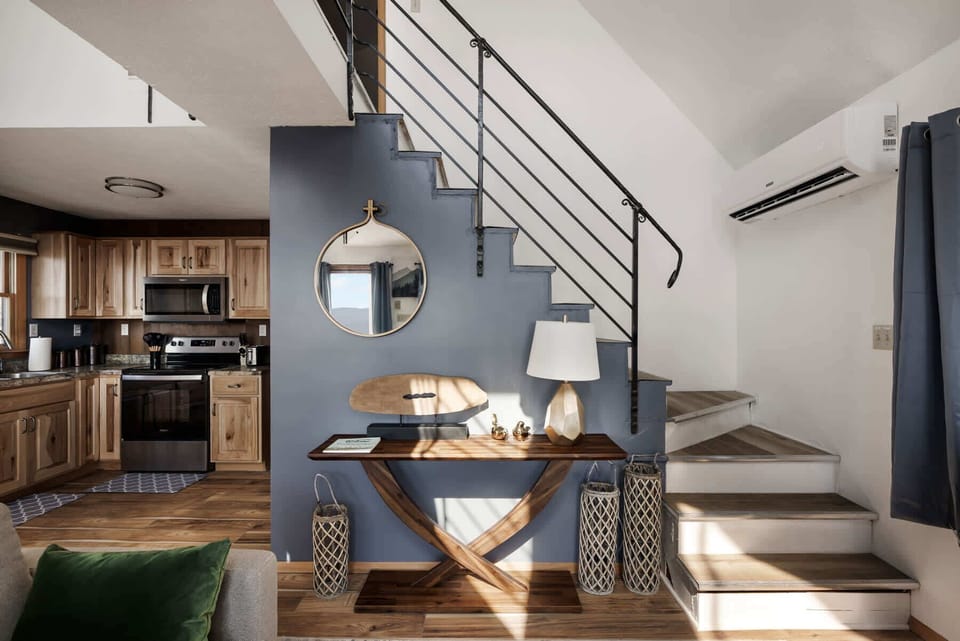 Modern staircase area with decorative wooden console and natural light.