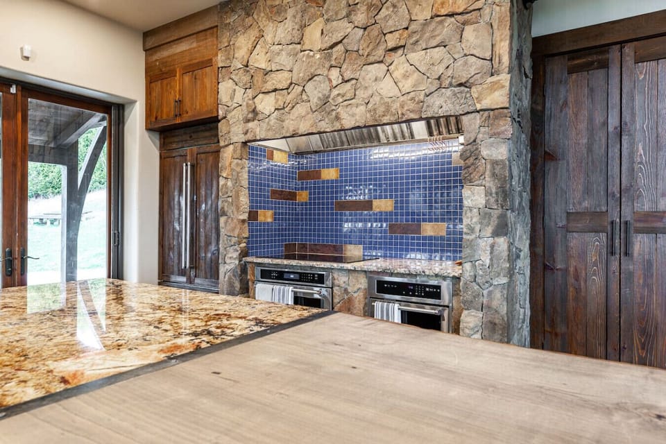 Fully equipped kitchen with large island, premium appliances, and seating for 20+ — great for group meals and events.