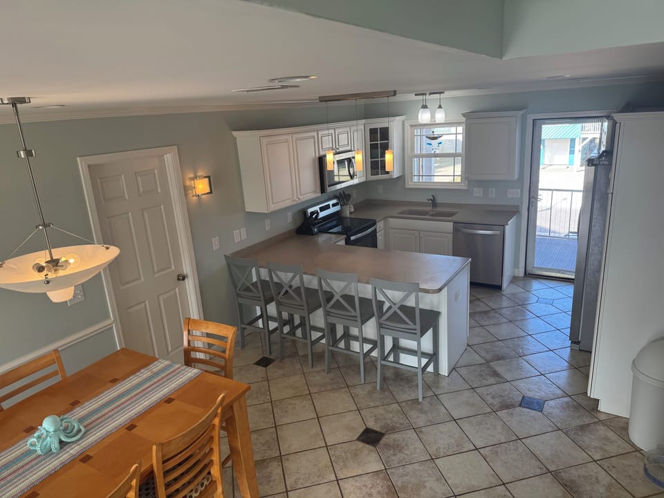 Kitchen with door that leads out to a deck and elevator.