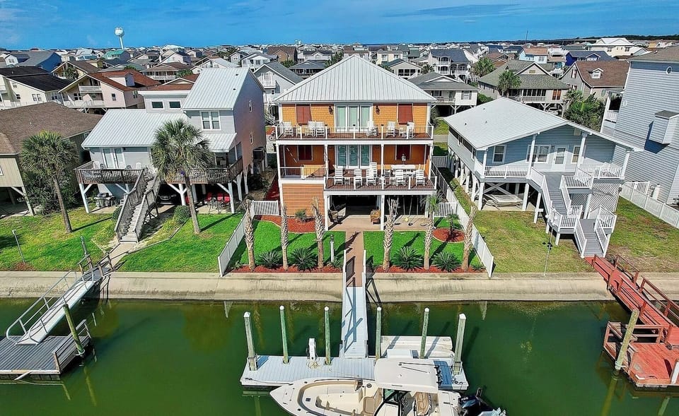 Arial photo of the back of the house located on a canal.   