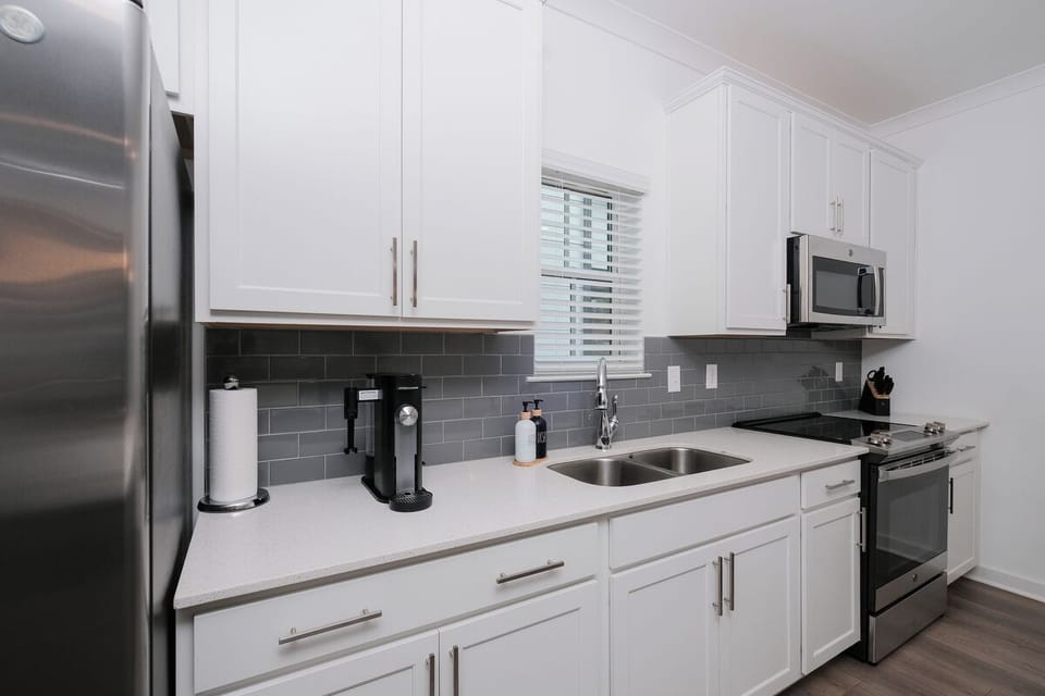 Sleek kitchen with barstools, stocked for cooking & gathering