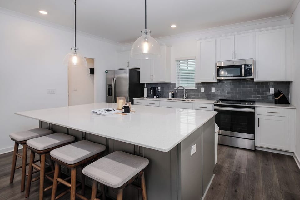 Sleek kitchen with barstools, stocked for cooking & gathering
