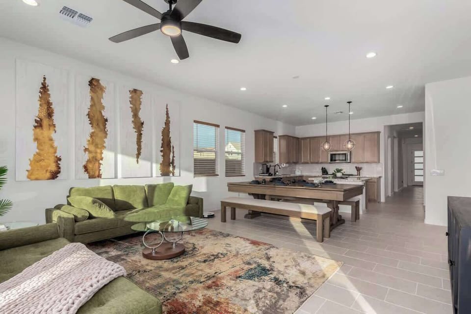 Relax in the spacious living room with plush seating, a smart TV, and a sleek pool table that doubles as a dining table, perfect for both game nights and enjoying a nice meal. 