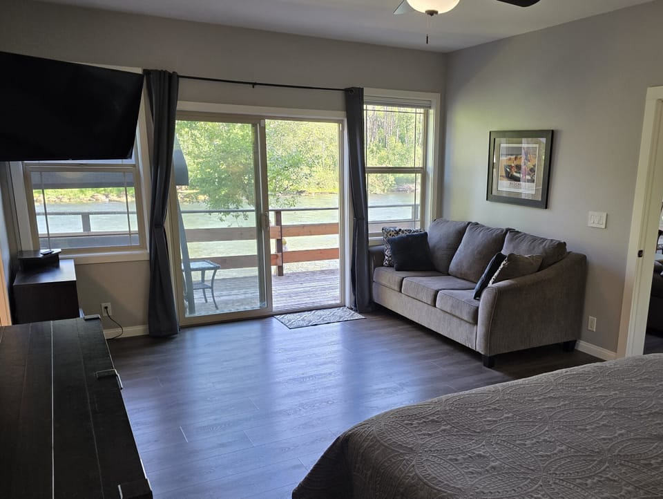 view from bed to river, with living room to the right & bathroom to the left