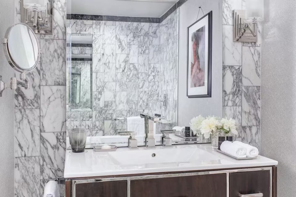 Refresh each morning in a bright, marble-clad vanity space.