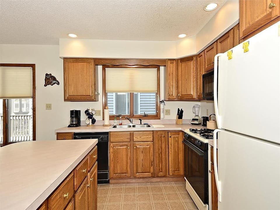 Fully equipped kitchen with warm wood cabinetry, modern appliances, and ample counter space—ideal for preparing meals for the whole group.