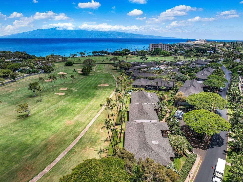 Aerial view of Maui Eldorado framed by lush golf course greens and shimmering ocean views