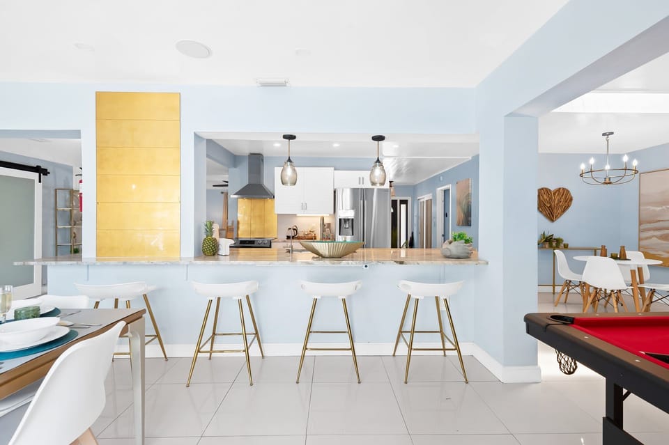 Start the day at the breakfast bar with fresh coffee and conversation. This open kitchen makes family meals easy and stress-free on your vacation. #FortLauderdaleAirbnb #FamilyVacationRental #FloridaStay
