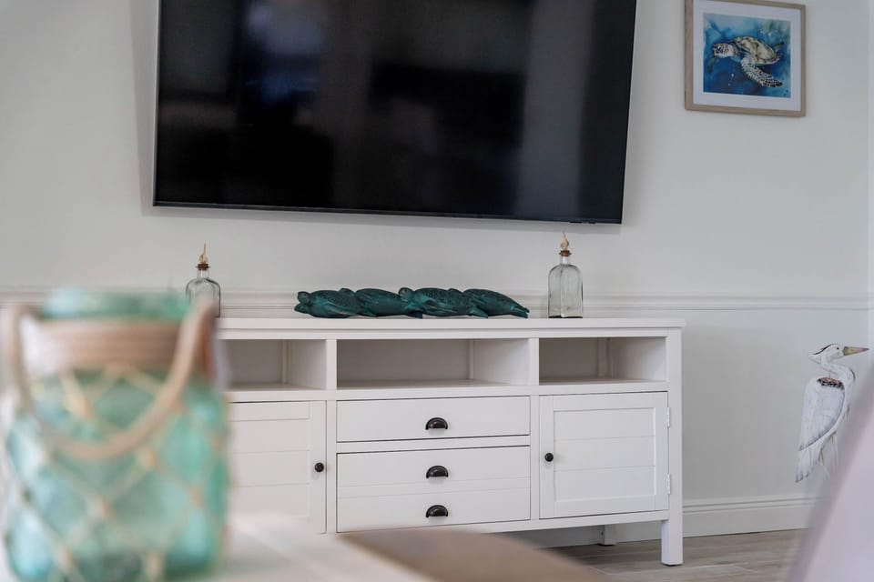 Relax and unwind in the spacious living room, complete with a large flat-screen TV for all your entertainment needs. Whether you're catching up on your favorite shows, streaming movies, or enjoying a family movie night, this cozy space has everything