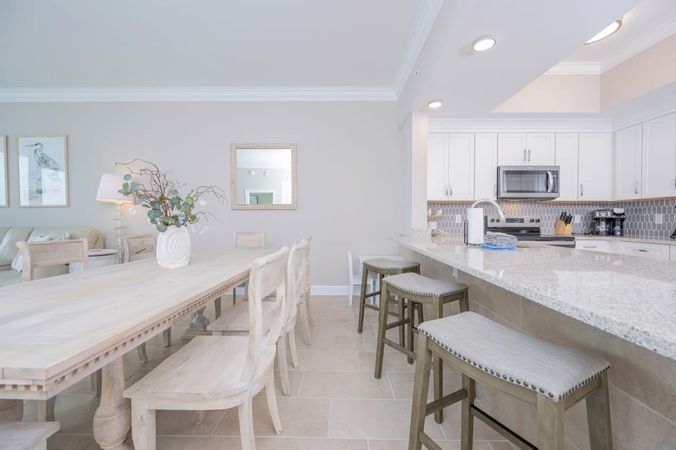Dine at the table surrounded by coastal decor, with a view of the stylish kitchen space