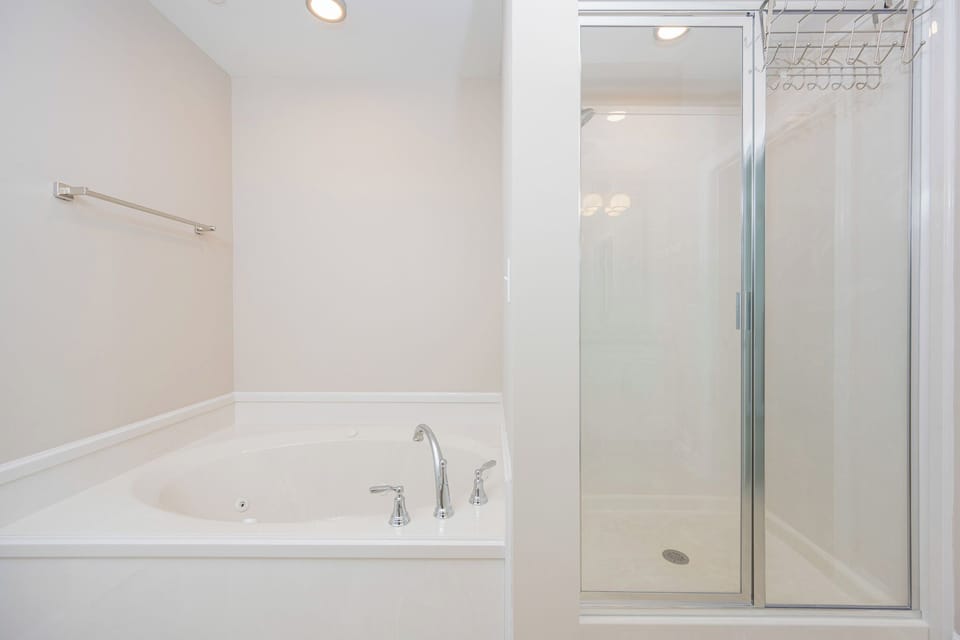 Indulge in relaxation with a spacious jetted tub and a separate walk-in shower in this elegant master bath