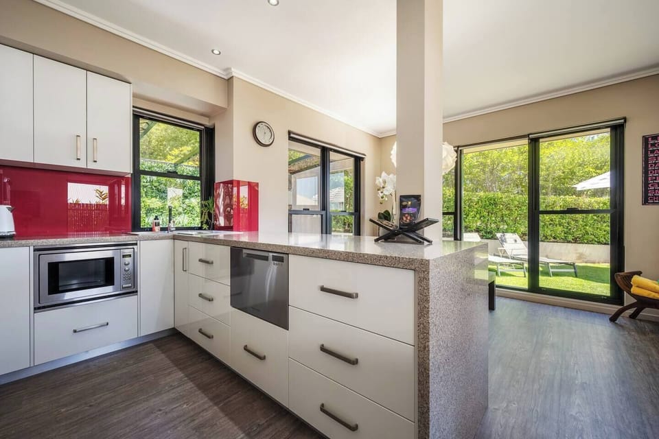 Prepare a lazy breakfast or hearty lunch in the well-equipped kitchen, featuring stone benchtops, an oven, dishwasher, and a coffee machine to elevate your morning ritual.