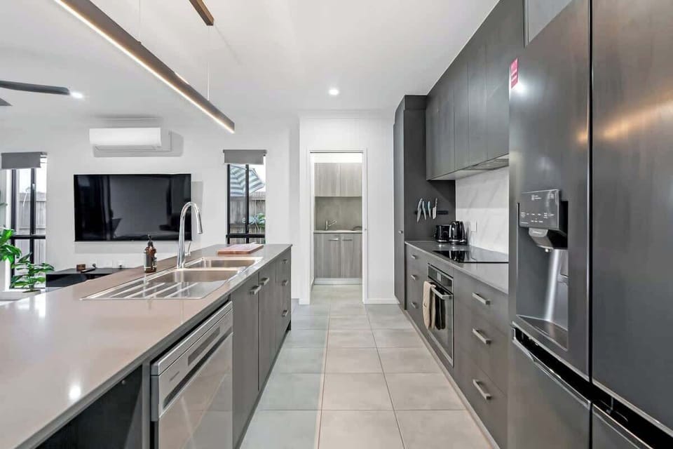 Create effortless meals in a chic kitchen with sleek black cabinetry, modern appliances, and a spacious island perfect for prepping, plating, or simply chatting over coffee.