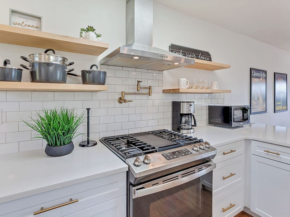 Bright kitchen with stainless appliances, large windows, and modern finishes