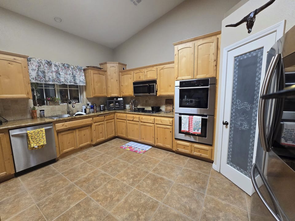 Large kitchen with upgraded appliances and pantry.