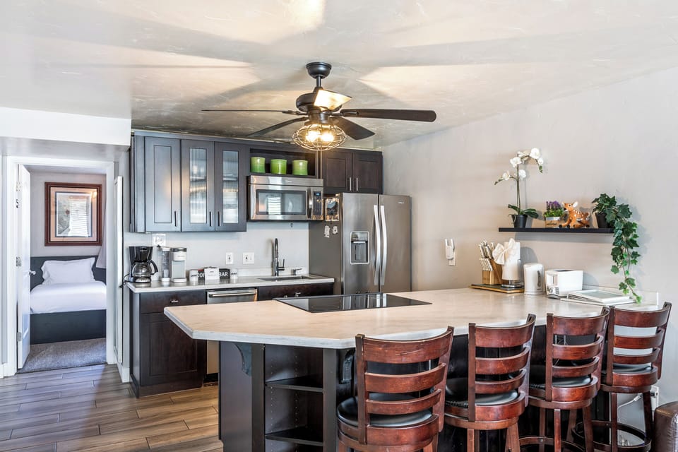 - Fully equipped kitchen with modern appliances  
- Large island countertop and bar stool seating  
- Vacation condo with stylish open plan design