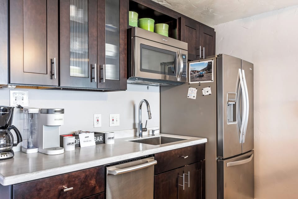 - Modern kitchen with stainless appliances and sink  
- Stocked with essentials for comfortable dining  
- Vacation rental condo with stylish dark cabinetry