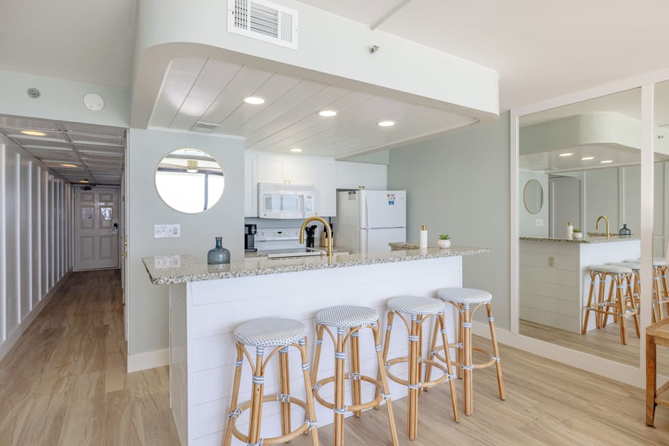 Modern kitchen with a granite countertop and seating for four.
