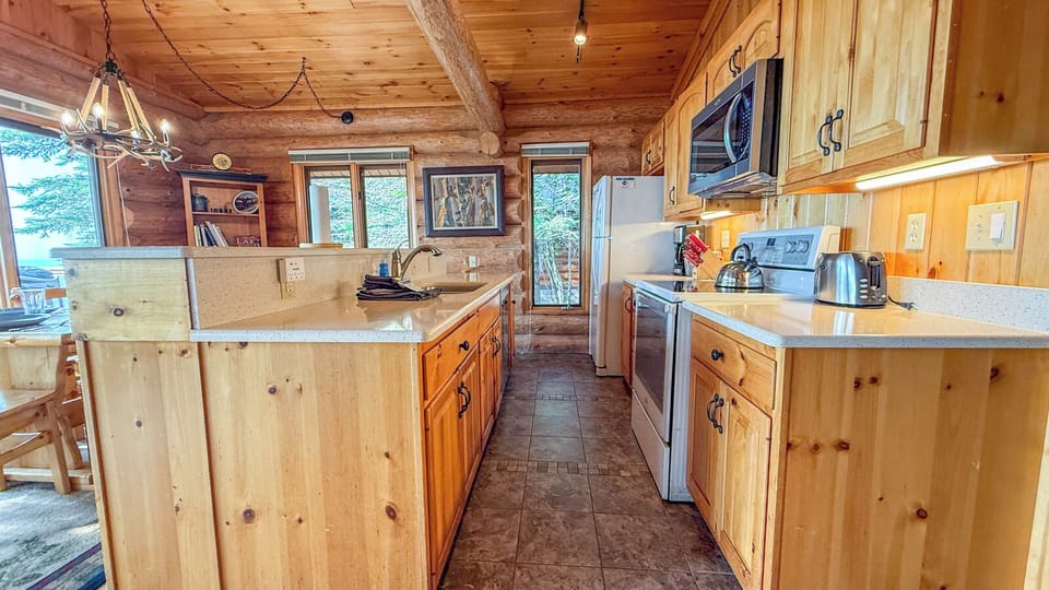 Your fully-equipped kitchen features rustic pine cabinetry, granite counters, and all the modern appliances you need to whip up meals in the heart of this cozy log cabin retreat.