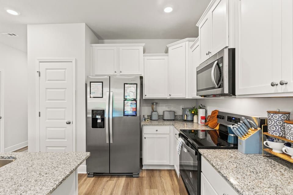 Sleek modern kitchen with white cabinetry, stainless steel appliances
