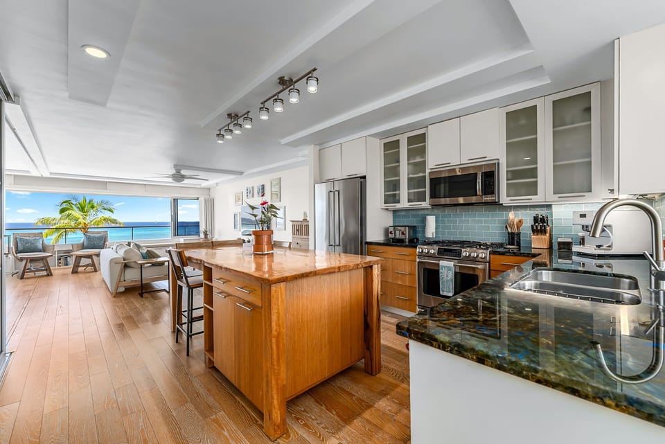 Gourmet-style kitchenette with granite counters, full-size fridge, and custom cabinetry.