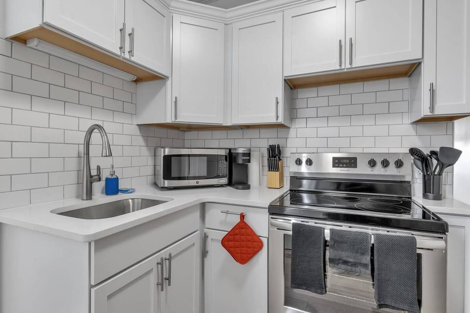Completely rebuilt kitchen with quartz countertops, soft close cabinets, crown molding, subway tile backsplash and stainless steel appliances