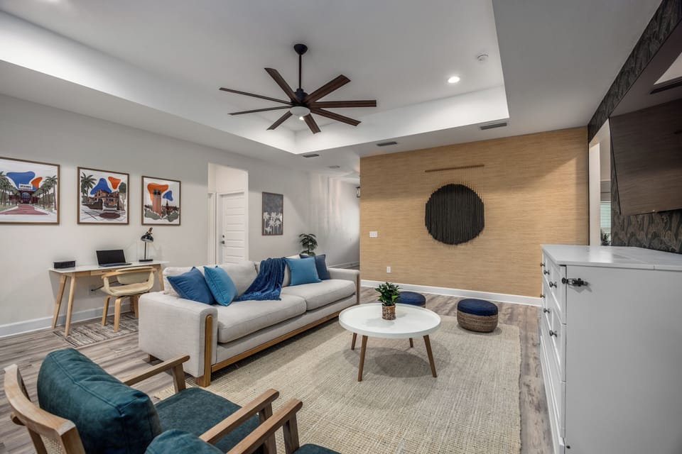 Living room ceiling fan, plush couch and dedicated workspace