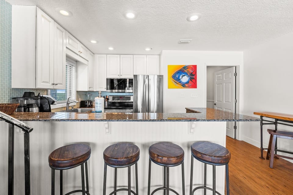 Gather around the island for drinks, snacks, or stories. This spacious bar top is perfect for mingling after a day at the beach.