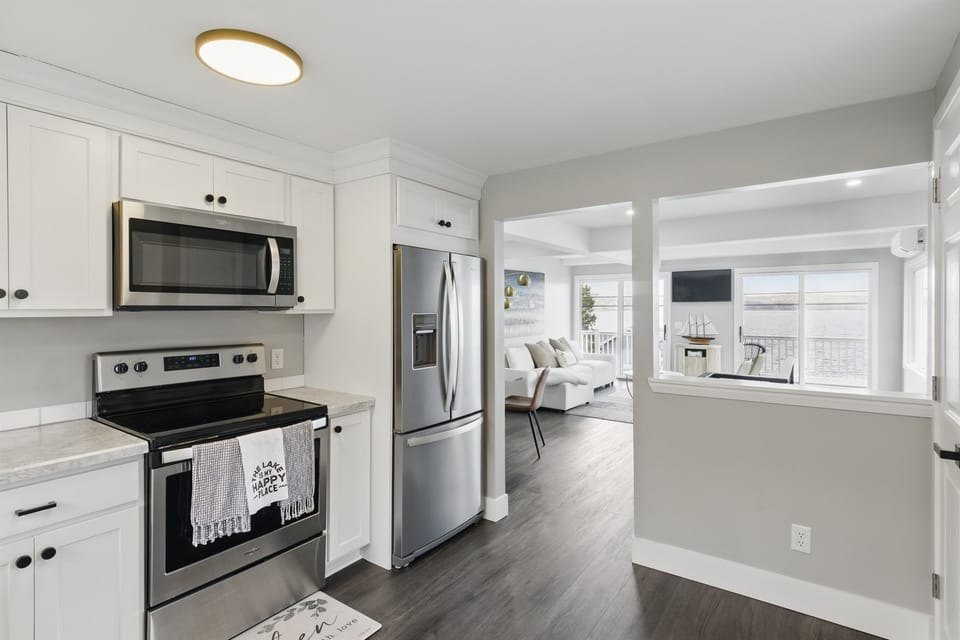 Modern lakeview kitchen featuring stainless steel appliances, white shaker cabinets, and sleek countertops – perfect for home-cooked meals with a view.