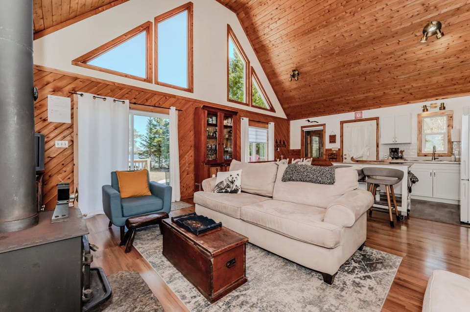 Bright open-concept living space with vaulted ceilings, stunning lake views, and easy access to outdoor adventures from this beautiful rental.